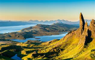 A dramatic coastline view of the Scottish Isles Loop with a winding road